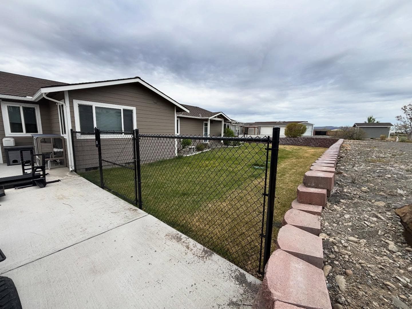 Black chain link fence along a backyard in the Columbia Basin